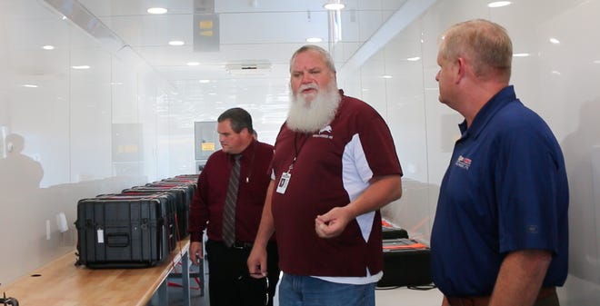 Brownwood High School teacher Edward Yantis (center) explains what's inside the electronics, robotics and drone technology trailer as visitors including Brownwood superintendent Dr. Joe Young (left) and Bruner Auto Group general manager Cory Howard listen.