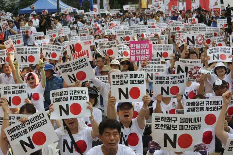 South Korean protesters stage a rally to denounce Japan's new trade restrictions on South Korea in front of the Japanese embassy in Seoul, South Korea, Saturday, Aug. 3, 2019. Japan's Cabinet on Friday approved the removal of South Korea from a list of countries with preferential trade status, prompting retaliation from Seoul where a senior official summoned the Japanese ambassador and told him that South Koreans may no longer consider Japan a friendly nation. The placards read: "We denounce Japanese Prime Minister Shinzo Abe." (AP Photo/Ahn Young-joon)