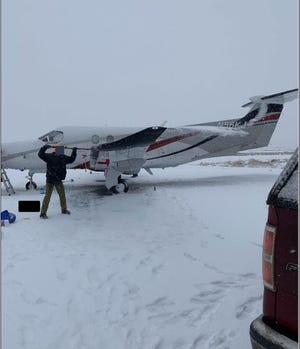Someone clears snow off the Pilatus PC-12 in Chamberlain on November 30, 2019. The plane would later crash, killing nine and injuring three.